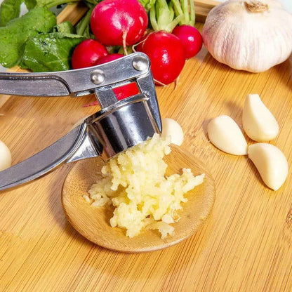 Heavy-duty garlic crusher in action with fresh garlic cloves  